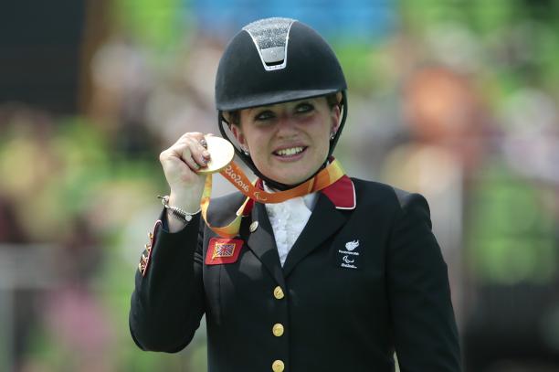 female Para equestrian rider Natasha Baker on the podium with her gold medal