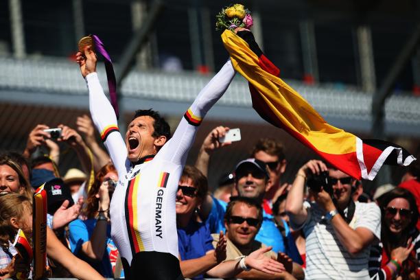 German Para cyclist Michael Teuber pumps his fist and celebrates with a German flag