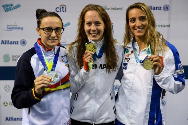 three female Para swimmers, with Naomi Maike Schnittger in the centre, holding up their medals