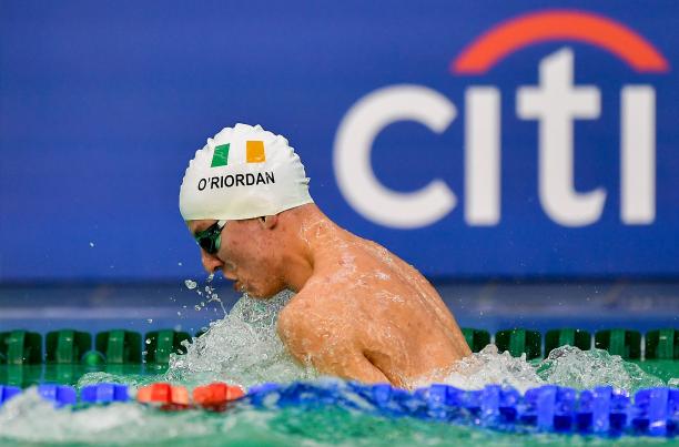 Athlete swimming with cap showing Ireland's flag