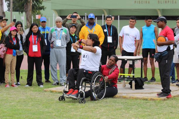 a male wheelchair athlete prepares to throw a shot put