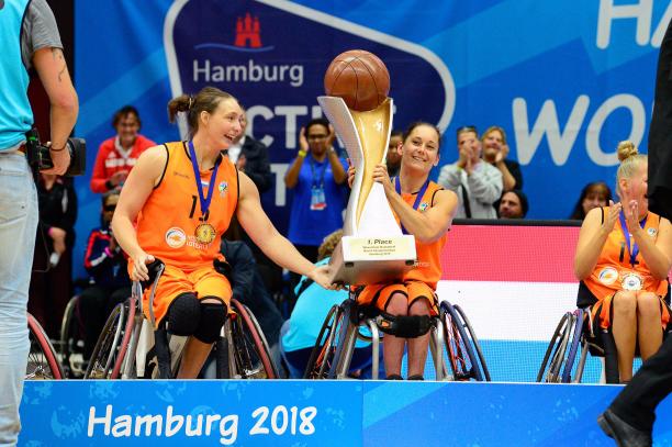 female wheelchair basketballer Carina de Rooij lifts up the trophy