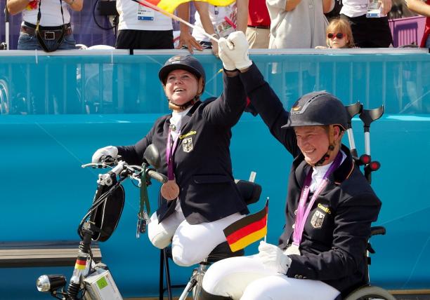 female Para equestrian rider Angelika Trabert celebrates with the German flag and her medal