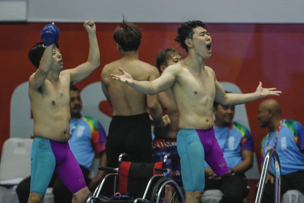 Unified Korean Team - Indonesia 2018 three male Para swimmers celebrate at the edge of the pool