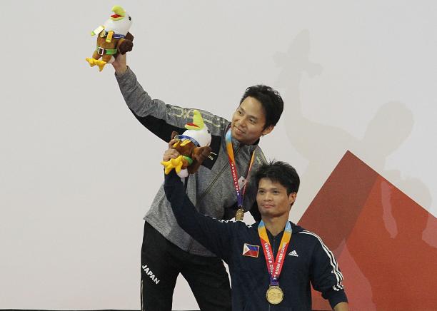male Para swimmers Daisuke Ejima and Ernie Gawilan on the podium raising their arms