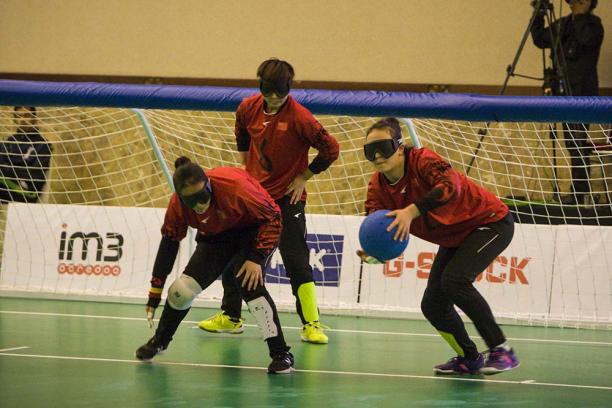 China women's goalball - Indonesia 2018 three female Chinese goalball players talking in front of the goal