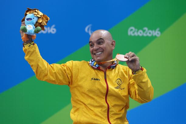 Moises Fuentes - Rio 2016 a male Para swimmer holds his bronze medal aloft