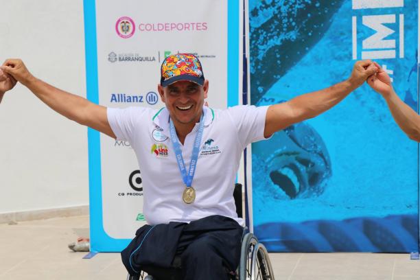 Colombian swimmer Moisés Fuentes smiling on the podium