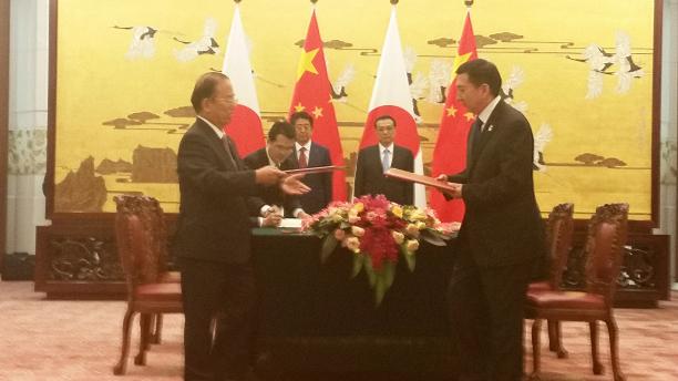 Tokyo 2020 and Beijing 2022 Memorandum of Understanding Beijing 2022 and Tokyo 2020 men in suits in a room exchanging documents