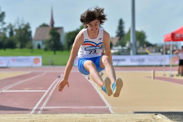 Youth athletics a male Para athlete jumps into a long jump sandpit