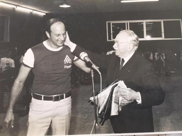 Reuven Heller and Sir Ludwig Guttman Reuven Heller puts his arm on the shoulder of Sir Ludwig Guttman who is touching his face