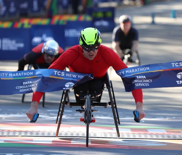 Daniel Romanchuk - 2018 New York Marathon male wheelchair racer Daniel Romanchuk breaks the tape on the finish line ahead of two other wheelchair racers