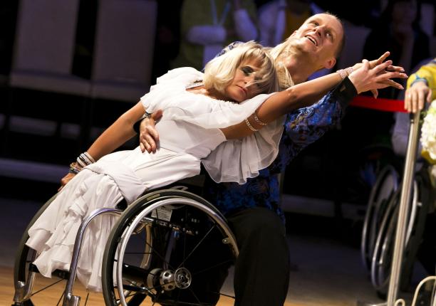 A female wheelchair dancer in a move with her able-bodied male partner