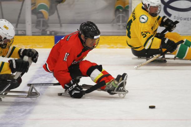 A man in a sledge playing Para ice hockey