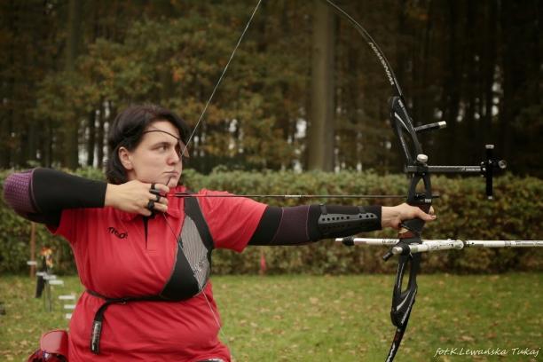 female Para archer Milena Olszewska draws back an arrow and prepares to shoot