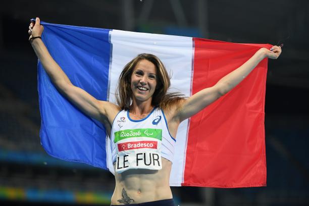a female Para athlete holds up a French flag