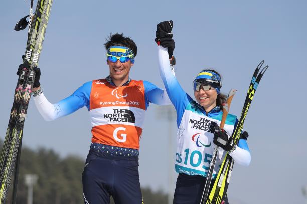 Oksana Shyshkova - PyeongChang 2018 female Para Nordic skier Oksana Shyshkova holds hands with her guide as they raise their arms in victory