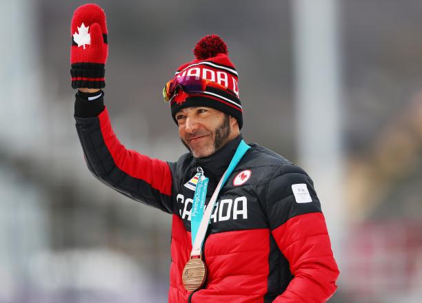 male Para Nordic skier Brian McKeever waves with a gold medal around his neck