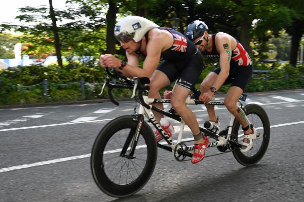 Dave Ellis male Para triathlete Dave Ellis cycling on a tandem bike behind his guide
