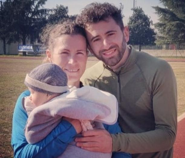 Arjola Dedaj Female Para athlete Arjola Dedaj standing next to her male partner holding a baby boy
