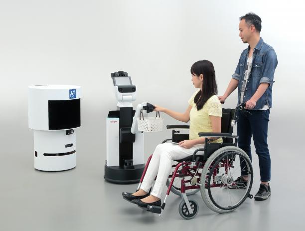 Tokyo 2020 Robot Project a person in a wheelchair having their basket held by a robot