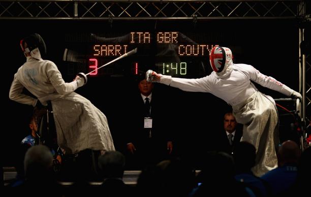 male wheelchair fencer Alessio Sarri leans back to avoid another fencer's foil