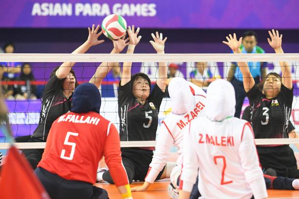 Sitting volleyball - women two female sitting volleyball teams contesting the ball on court
