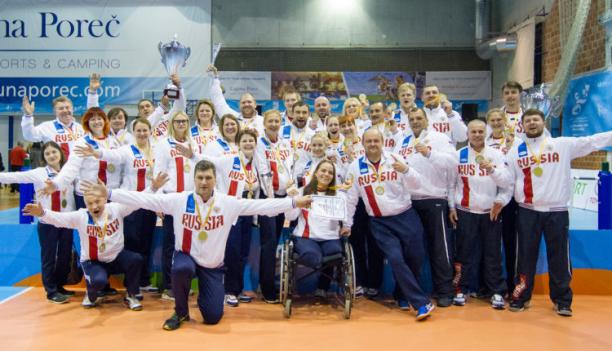 a group of male and female sitting volleyball players celebrate