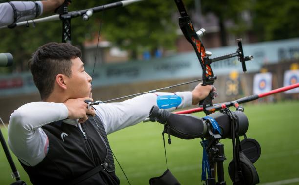 Kim Min Su - archery - South Korea Korean male archer pulls back on his bow string aiming for a target