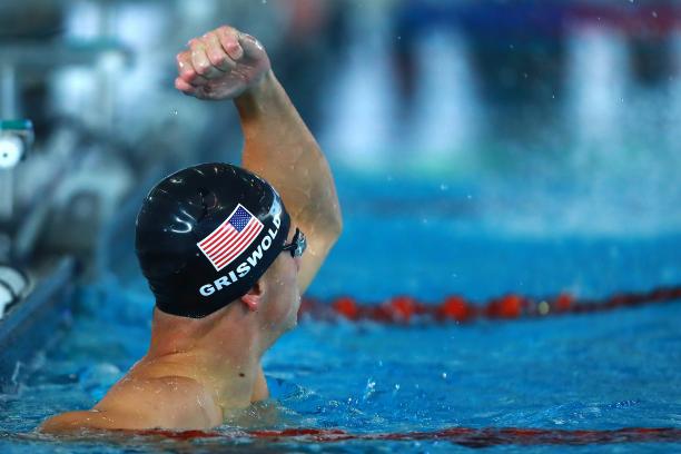 male Para swimmer Robert Griswold punches the air in the pool after winning a race