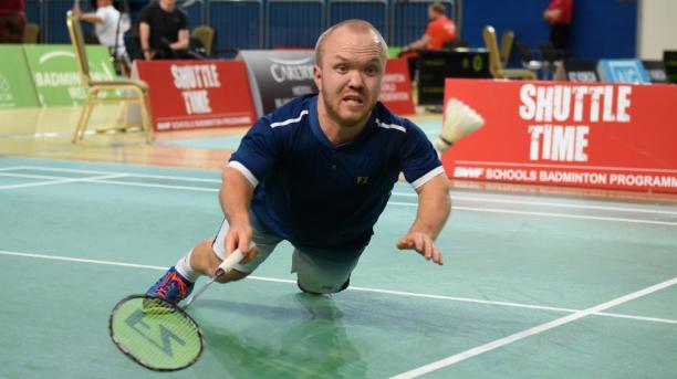 Short statured English badminton player dives for the birdie