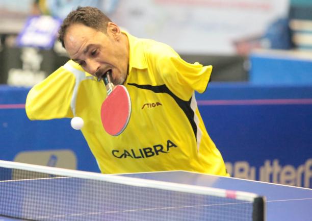 Ibrahim Hamadtou - Egypt - table tennis Egyptian male table tennis player holds racket in mouth and attempts to hit the ball