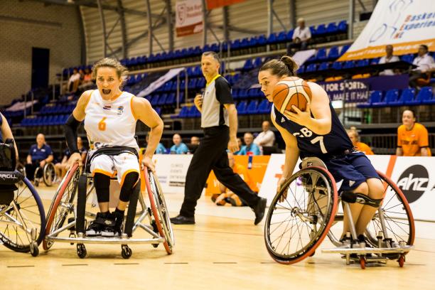 Helen Freeman and Jitske Visser - wheelchair basketball British female wheelchair basketball player makes a move with the ball while a Dutch player turns to defend her