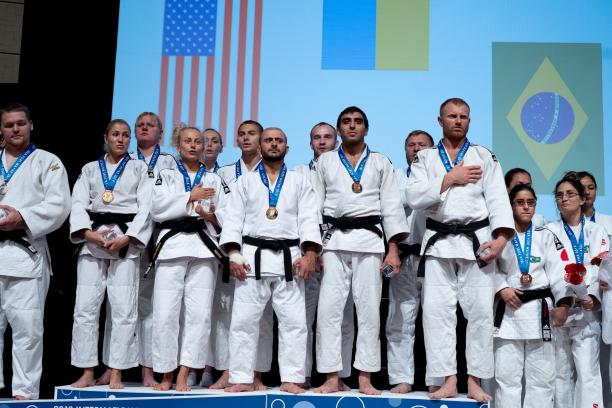 A group of vision impaired female and male judokas on the podium