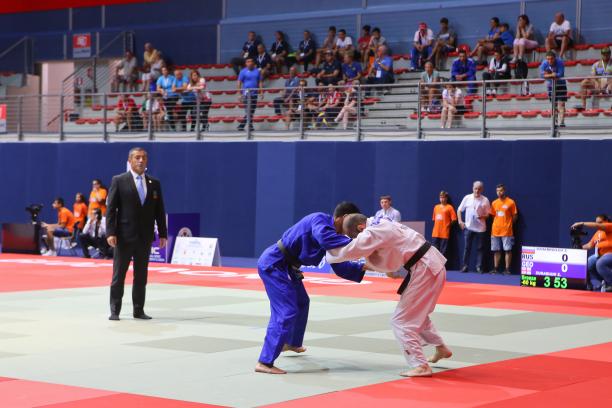 Judo - Europeans 2019 Russian and Georgian judokas grab each other on the tatami as the judge and spectators watch