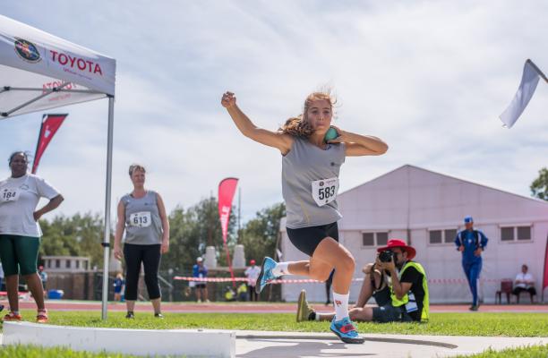 Simone Kruger - South Africa - Para Athletics A female teenage athlete competing in shot put watched by three people