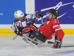 A picture of a two mens in wheelchairs playing ice hockey