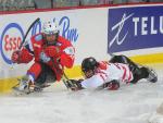 A picture of two men in a sledge playing ice sledge hockey.