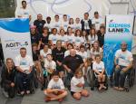 A group of participants pose in front of Paralympics New Zealand and Agitos Foundation banners.