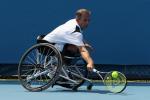 A picture of a man in a wheelchair playing tennis.