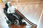 A picture of a girl in an electric wheelchair presenting a ramp.