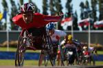 A picture of a man in a wheelchair racing on a track