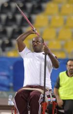 Man sitting, throwing a javelin