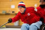 Man in a wheelchair doing curling