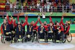 Group of men in wheelchairs celebrate after winning gold.