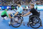 Two men in wheelchairs on a tennis court
