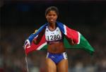 A picture of a woman on a track with the Namibian flag around her neck