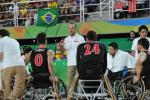 Coach surrounded by his men's wheelchair basketball team giving instuctions 
