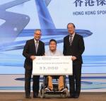 Man in middle in wheelchair holds giant check with two other men standing