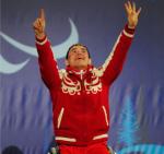 A picture of a man in a wheelchair celebrating his victory during a medal ceremony